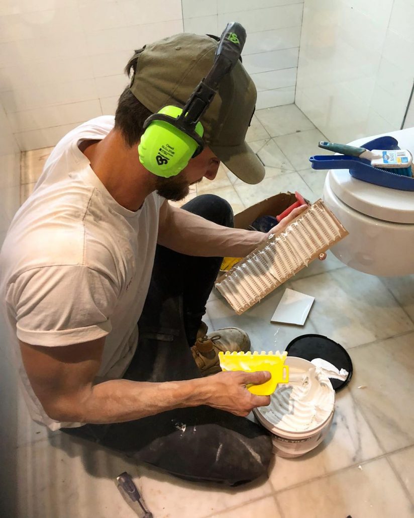 A worker of Pro Projects adding glue to tiles in a bathroom in the Double Bay Area of Sydney